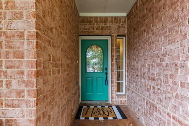 doorway to property featuring brick siding