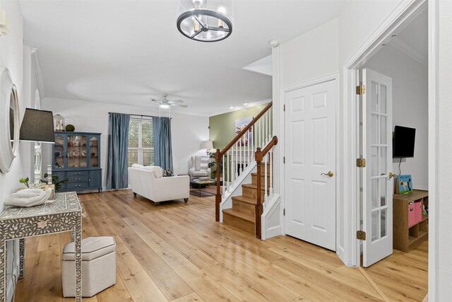 rec room featuring wood finished floors, crown molding, ceiling fan, and baseboards