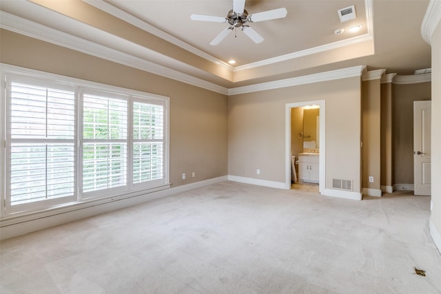 2813 Welborn St, Dallas, TX 75219 - unfurnished bedroom featuring ornamental molding, light colored carpet, a tray ceiling, baseboards, and connected bathroom