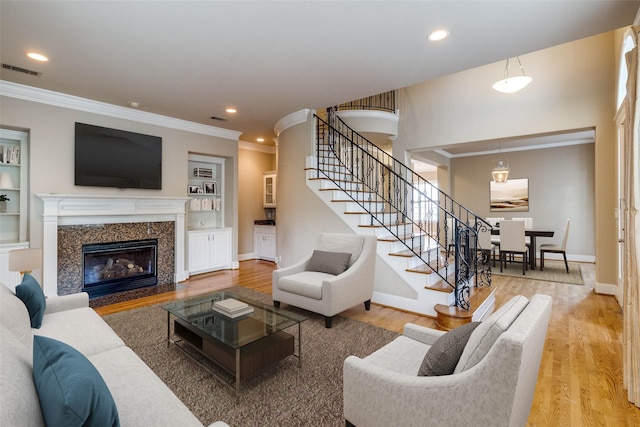 2813 Welborn St, Dallas, TX 75219 - living area with stairway, crown molding, wood finished floors, a fireplace, and recessed lighting