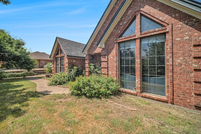 7508 Lake Highlands Dr, Fort Worth, TX 76179 - view of home's exterior with brick siding, a lawn, and a shingled roof