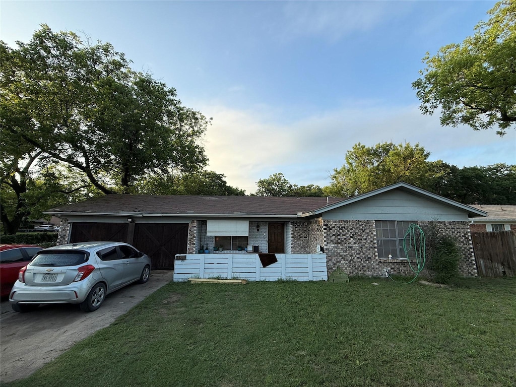 ranch-style home featuring driveway, brick siding, and a garage