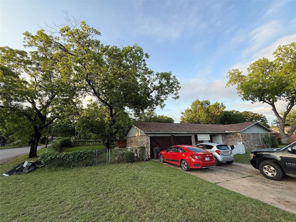 view of front of home featuring a front yard, concrete driveway, and an attached garage