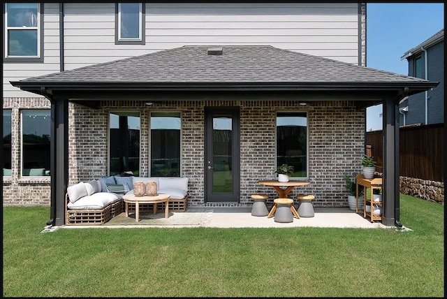 back of house with brick siding, a shingled roof, outdoor lounge area, and a patio area