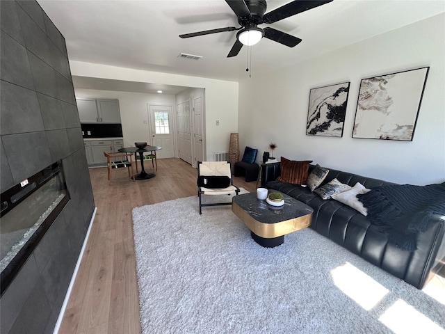 1034 Shawnee Trce, Grand Prairie, TX 75051 - living room featuring light wood-type flooring, a fireplace, and a ceiling fan