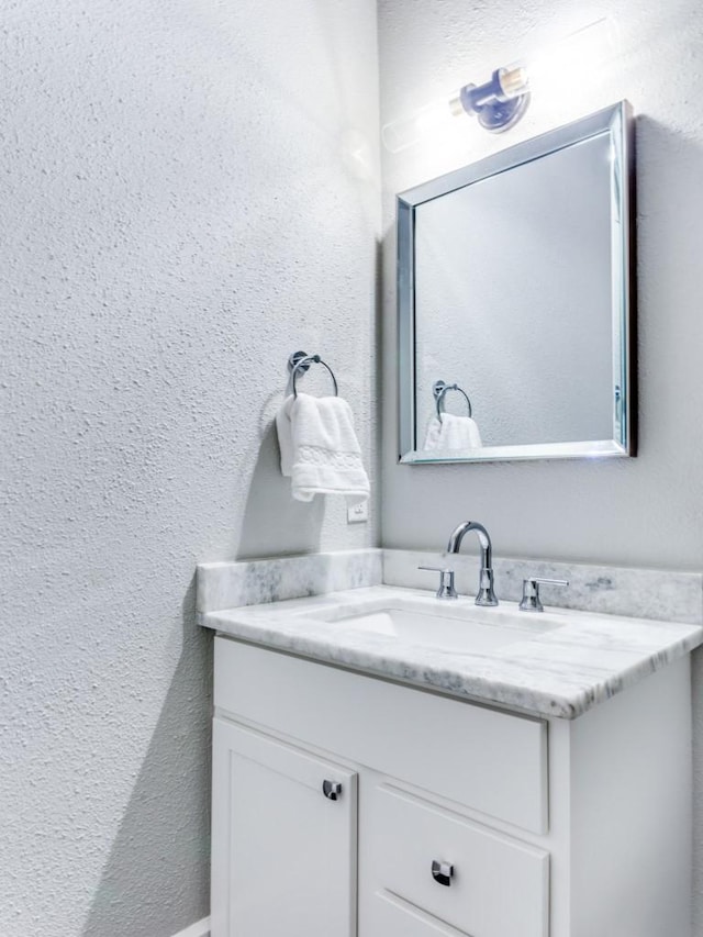 bathroom with vanity and a textured wall