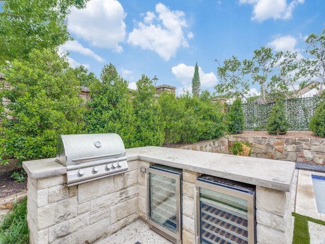 view of patio / terrace featuring area for grilling, wine cooler, and a fenced backyard