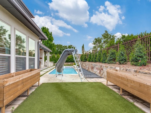 view of pool with a water slide and a patio area