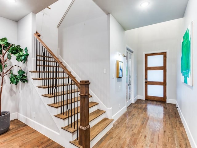 entrance foyer with wood finished floors, stairway, baseboards, and recessed lighting