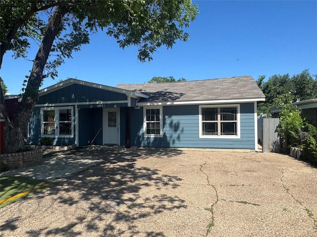 ranch-style house with fence and concrete driveway
