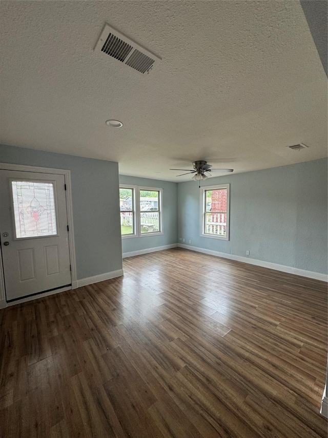 foyer entrance featuring wood finished floors, a textured ceiling, baseboards, and ceiling fan
