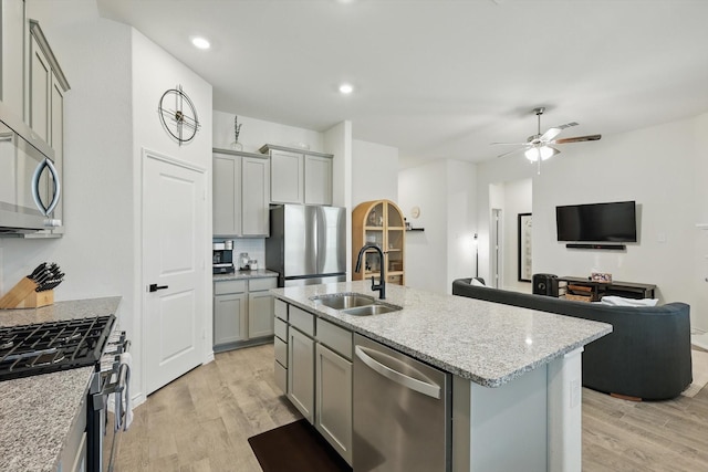 3409 Brady Starr Dr, Aubrey, TX 76227 - kitchen with a sink, stainless steel appliances, gray cabinetry, light wood-style floors, and ceiling fan