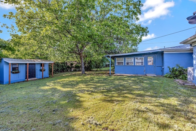 view of green lawn with an outdoor structure and a storage unit
