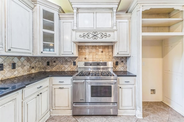 22924 County Road 223, Arp, TX 75750 - kitchen with double oven range, dark countertops, decorative backsplash, glass insert cabinets, and light tile patterned flooring