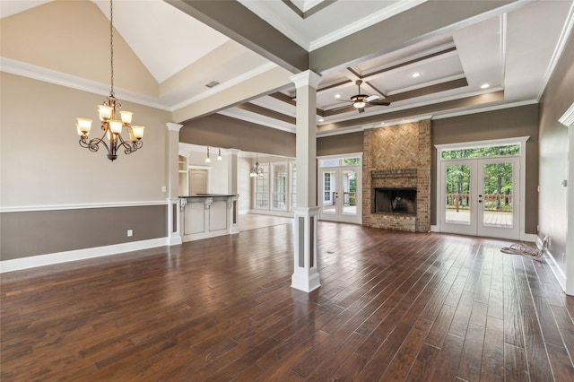 22924 County Road 223, Arp, TX 75750 - unfurnished living room featuring a chandelier, ornate columns, a brick fireplace, french doors, and ornamental molding