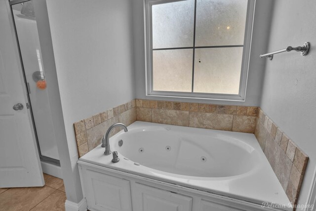 full bathroom with a shower stall, a tub with jets, and tile patterned floors