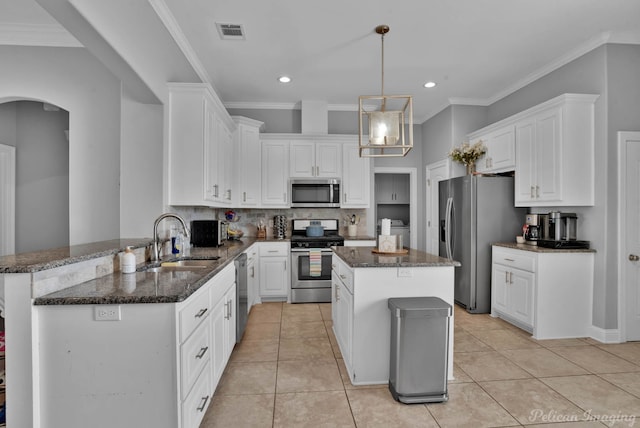 kitchen with stainless steel appliances, a sink, white cabinets, recessed lighting, and crown molding