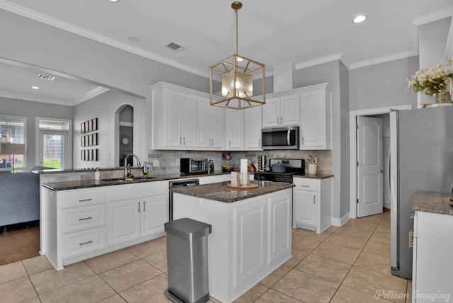 kitchen featuring stainless steel appliances, a sink, backsplash, white cabinetry, and crown molding