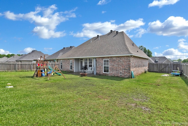back of property featuring brick siding, a playground, a fire pit, and a shingled roof