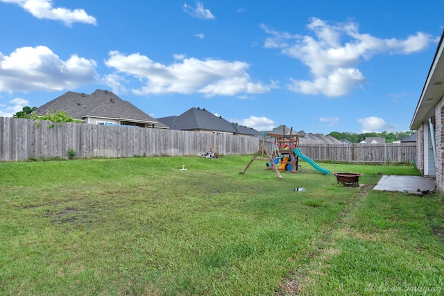 view of yard with a playground and an outdoor fire pit