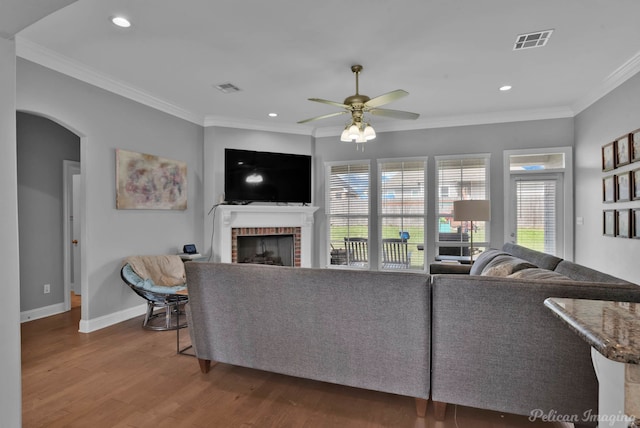 living area featuring wood finished floors, plenty of natural light, a ceiling fan, a fireplace, and recessed lighting