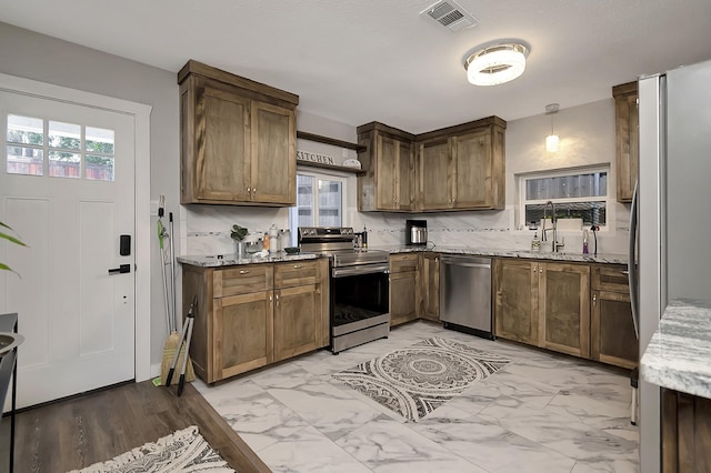 14070 Rucker St, Azle, TX 76020 - kitchen with stainless steel appliances, light marble finish flooring, a sink, and light stone counters
