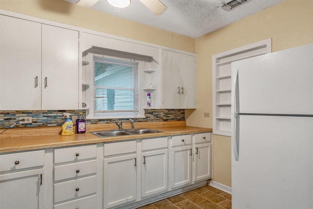 1621 Baseball Loop, Diana, TX 75640 - kitchen with freestanding refrigerator, a sink, backsplash, light countertops, and a textured ceiling