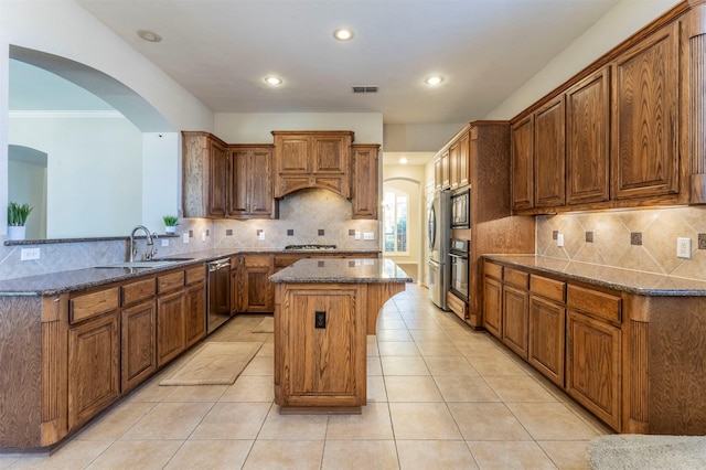 1364 Aubrey Ln, Frisco, TX 75033 - kitchen with appliances with stainless steel finishes, a center island, arched walkways, a sink, and recessed lighting