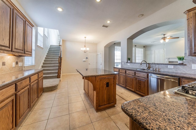 1364 Aubrey Ln, Frisco, TX 75033 - kitchen featuring appliances with stainless steel finishes, a sink, a ceiling fan, arched walkways, and backsplash