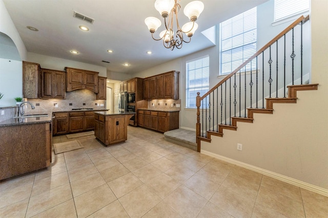 1364 Aubrey Ln, Frisco, TX 75033 - kitchen with a sink, decorative backsplash, a kitchen island, a chandelier, and black appliances