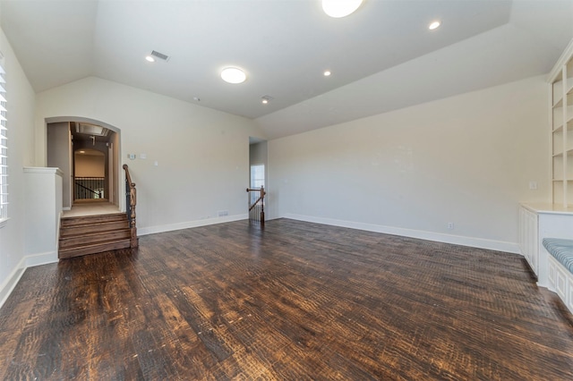 1364 Aubrey Ln, Frisco, TX 75033 - unfurnished living room featuring vaulted ceiling, arched walkways, baseboards, stairs, and dark wood-style flooring