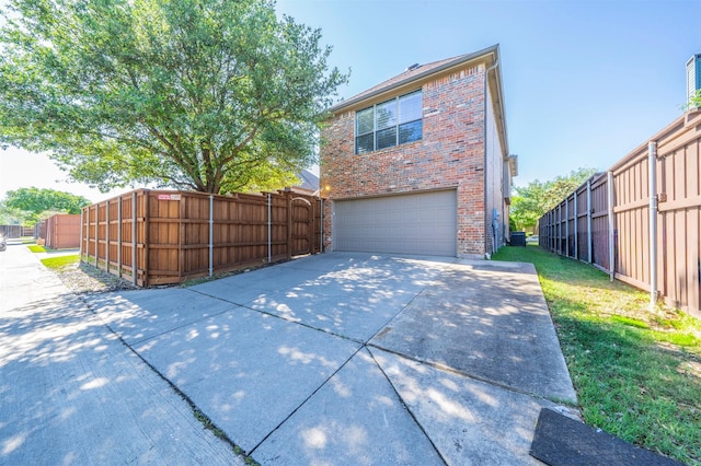 1364 Aubrey Ln, Frisco, TX 75033 - view of side of property with an attached garage, brick siding, concrete driveway, and fence