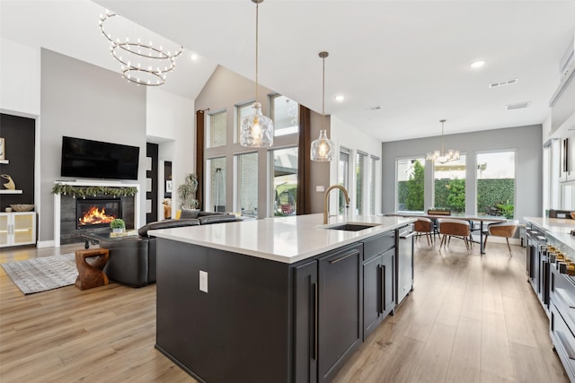 kitchen featuring a sink, a chandelier, light wood-type flooring, light countertops, and recessed lighting