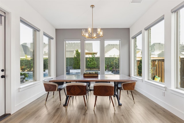 sunroom featuring a chandelier and healthy amount of natural light