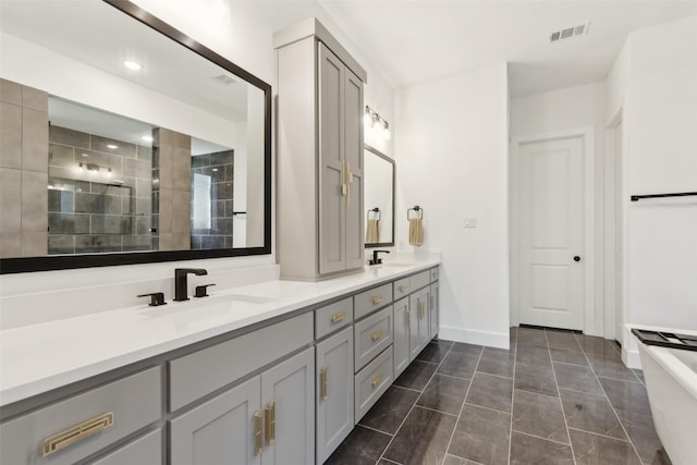 bathroom featuring double vanity, a tile shower, baseboards, a freestanding tub, and marble finish flooring