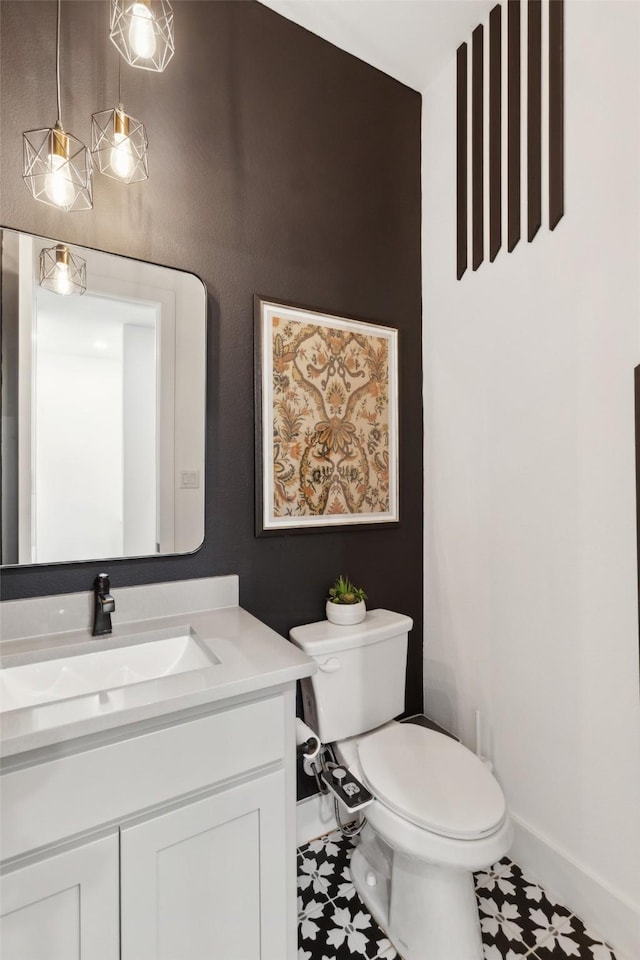 half bathroom with baseboards, toilet, and vanity