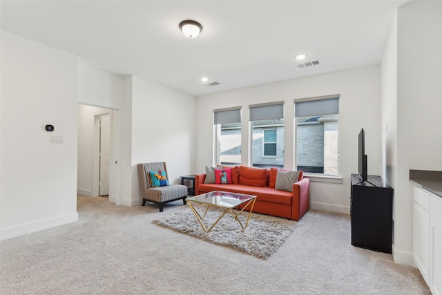 living room featuring light colored carpet, baseboards, and recessed lighting