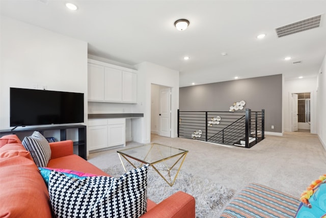 living area featuring light colored carpet, baseboards, and recessed lighting