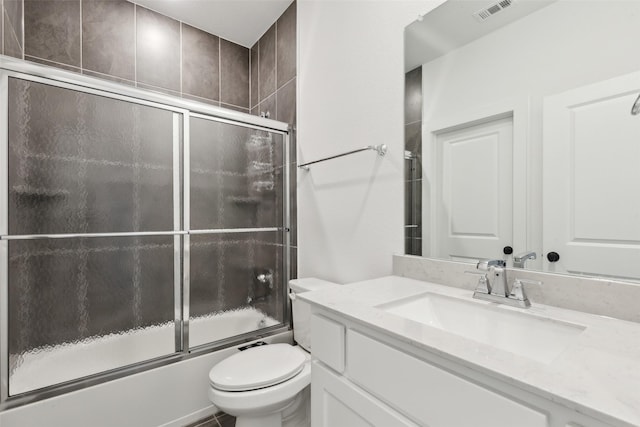 bathroom featuring combined bath / shower with glass door, toilet, and vanity