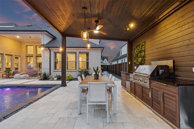 patio terrace at dusk featuring a grill, area for grilling, fence, outdoor dining space, and an outdoor pool