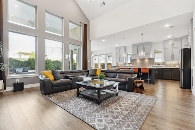 living area featuring light wood-style floors, lofted ceiling, and recessed lighting