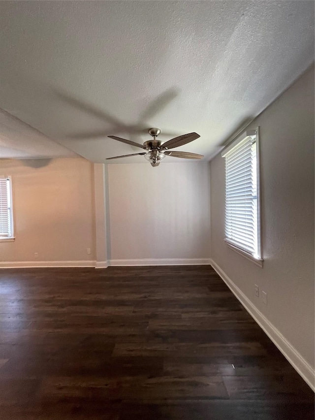 spare room with wood finished floors, ceiling fan, a textured ceiling, and baseboards