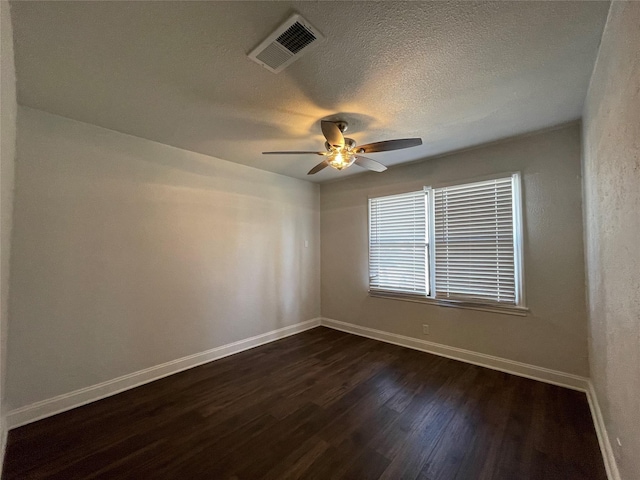 unfurnished room featuring baseboards, dark wood-style flooring, ceiling fan, and a textured ceiling