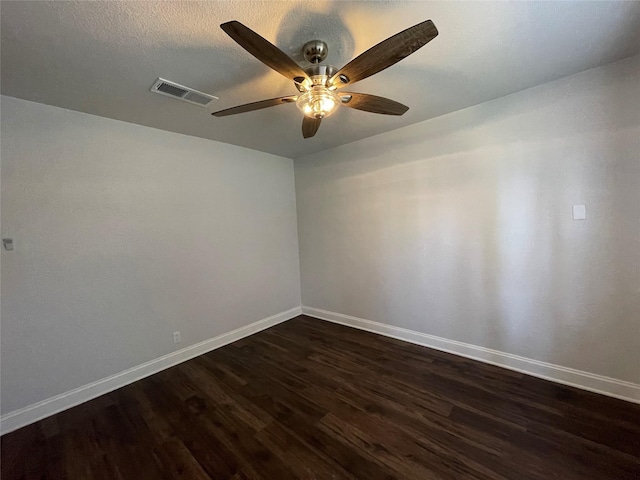 spare room featuring baseboards, dark wood-type flooring, and ceiling fan