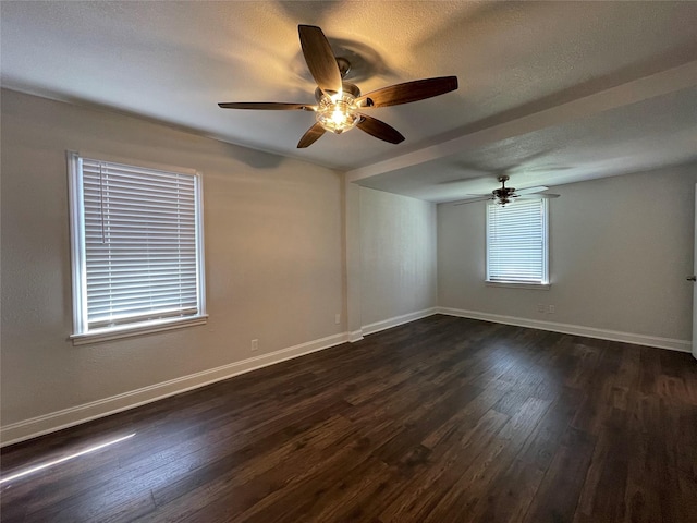 unfurnished room featuring a ceiling fan, dark wood-type flooring, baseboards, and a textured ceiling