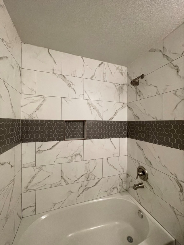 full bath with shower / bathtub combination and a textured ceiling