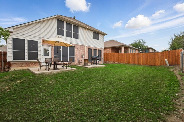 back of property at dusk with a patio area and brick siding