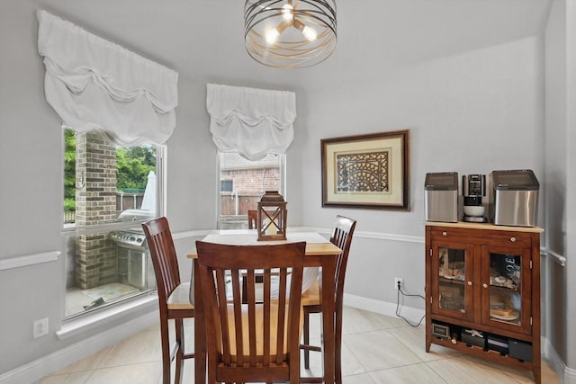 dining room featuring light tile patterned flooring, a chandelier, and baseboards