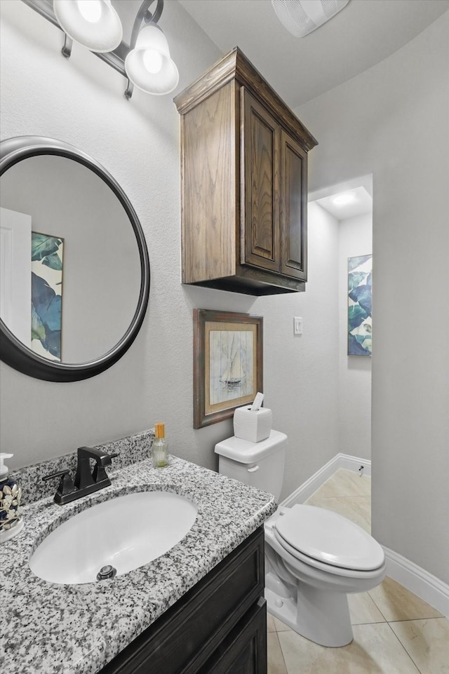 half bathroom featuring toilet, vanity, and tile patterned flooring