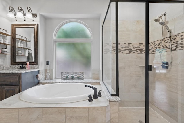 full bathroom featuring a stall shower, a garden tub, and vanity